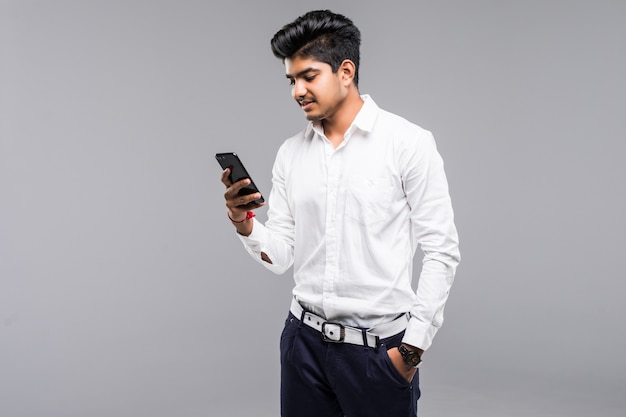 Indian business man using smartphone with white wall