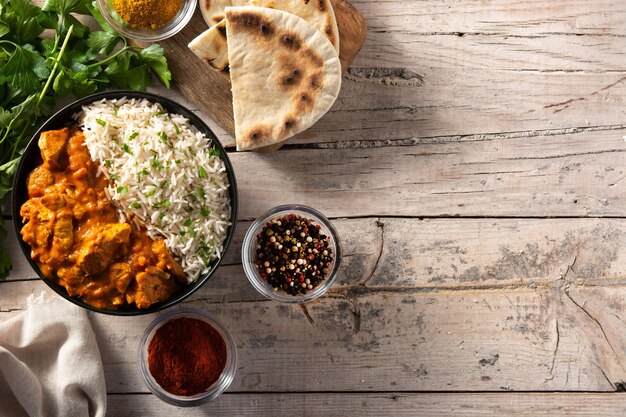 Indian butter chicken in black bowl on wooden table