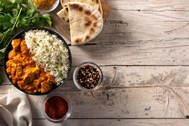 Indian butter chicken in black bowl on wooden table