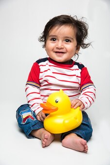 흰색 배경 위에 화려한 장난감이나 블록을 가지고 노는 인도의 귀여운 작은 아기 또는 유아 또는 유아,