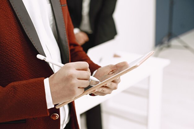 Indian lawyer or executive taking notes on tablet.