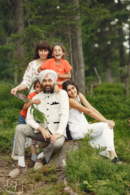 Indian man in a forest. Male in a traditional turban. International family in a summer forest.