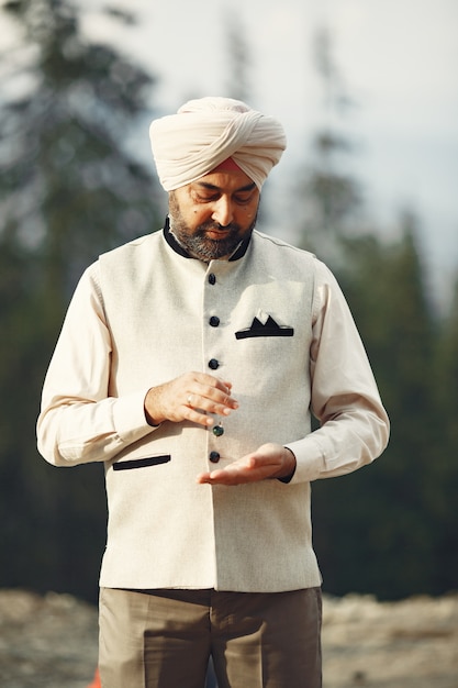 Free photo indian man in a mountains. male in a traditional turban. hinduist with mascot.