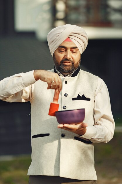 Indian man in a mountains. Male in a traditional turban. Hinduist with special things for rituals.