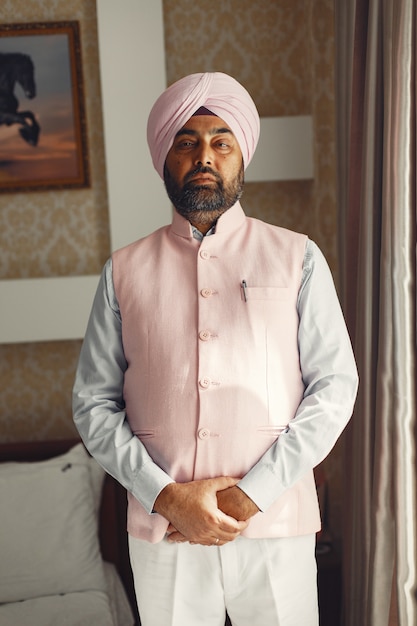 Indian man in a room. Male in a traditional turban. Hinduist in a room.