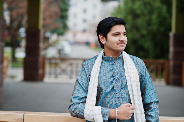 インド人男性が屋外でポーズをとった白いスカーフで伝統的な服を着る