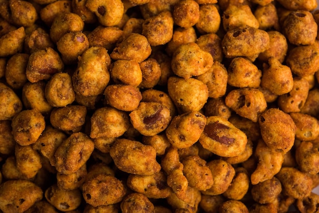 Indian spiced coated fried and crunchy masala peanut. popular namkeen snack. served in plate of bowl. selective focus