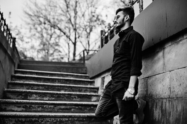 Indian stylish man at black shirt and sunglasses posed outdoor Black and white photo