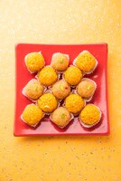Бесплатное фото Индийский сладкий мотихур ладду или бунди ладду из граммовой муки, очень маленькие шарики или бунди, которые обжариваются во фритюре и пропитываются сахарным сиропом перед тем, как сделать шарики
