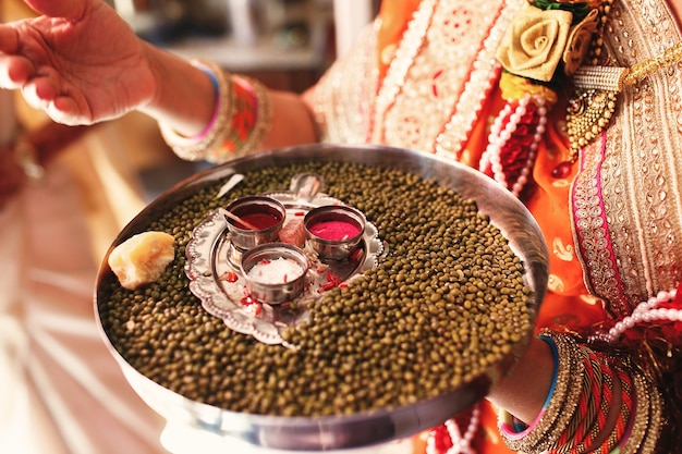 Indian woman carries a plate with turmeric and spices 