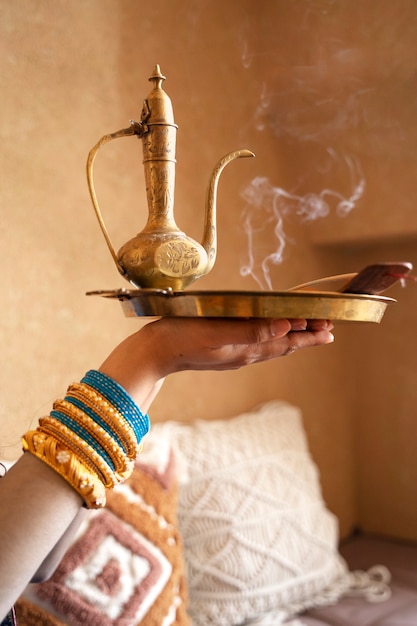 Indian woman holding tray with teapot