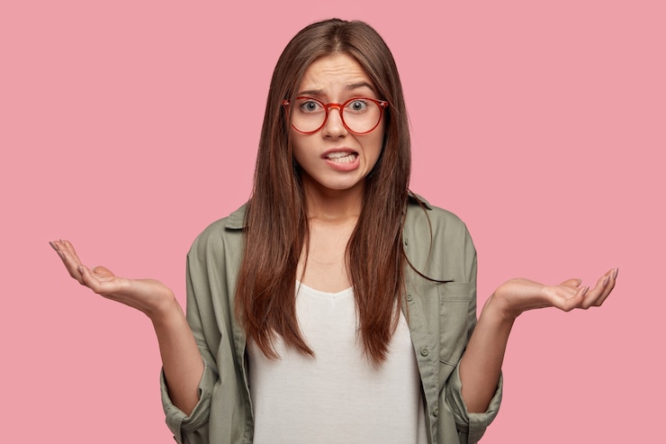 Free Photo indifferent puzzled student posing against the pink wall