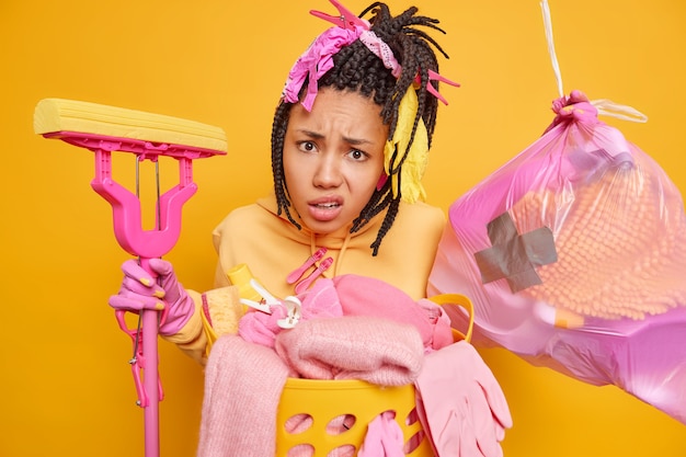 Free photo indignant african american woman has dreadlocks poses with garbage