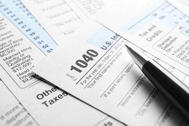 Формы индивидуальной налоговой декларации и ручка на столе