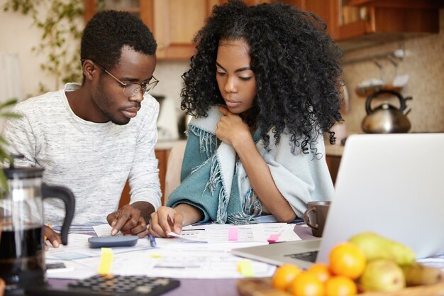 Indoor candid shot of young African-American couple doing paperwork together