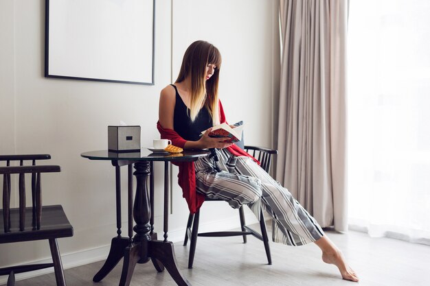 本を読んでかなりブルネットの女性の屋内ライフスタイルの肖像画