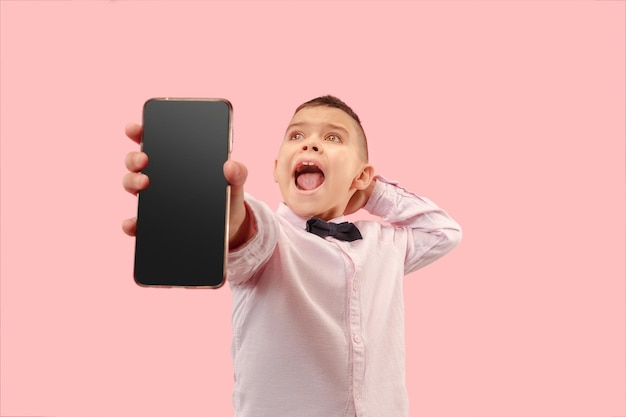 Indoor portrait of attractive young boy holding blank smartphone