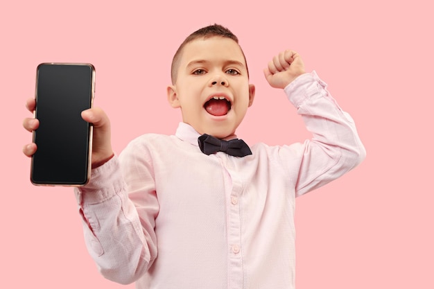 Indoor portrait of attractive young boy holding blank smartphone