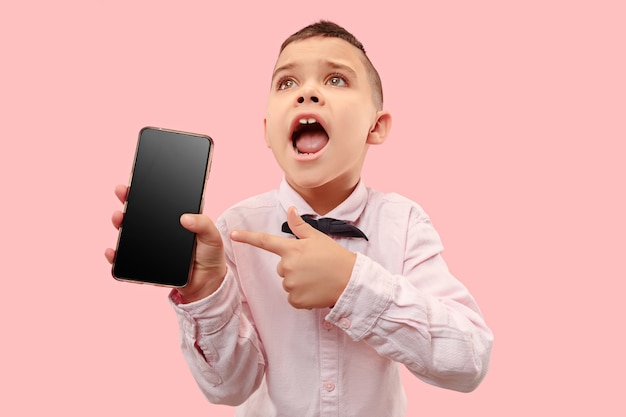 Indoor portrait of attractive young boy holding blank smartphone