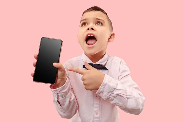 Крытый портрет привлекательного мальчика, держащего пустой смартфон