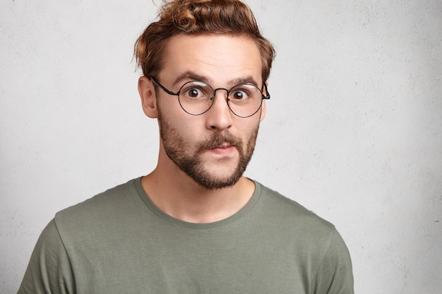 Indoor portrait of bearded young man with trendy hairstyle