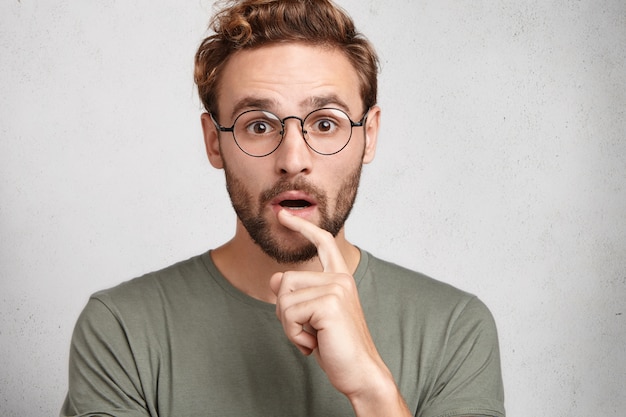 Indoor portrait of bearded young man with trendy hairstyle