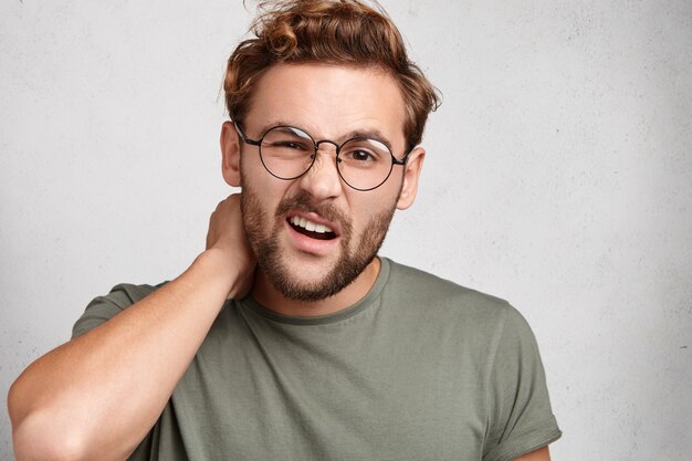 Indoor portrait of bearded young man with trendy hairstyle