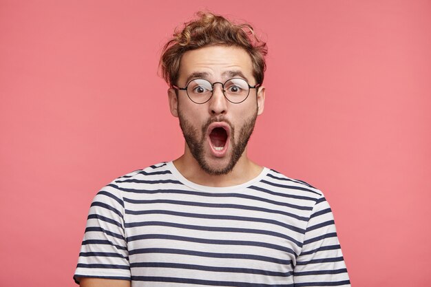 Indoor portrait of bearded young man with trendy hairstyle