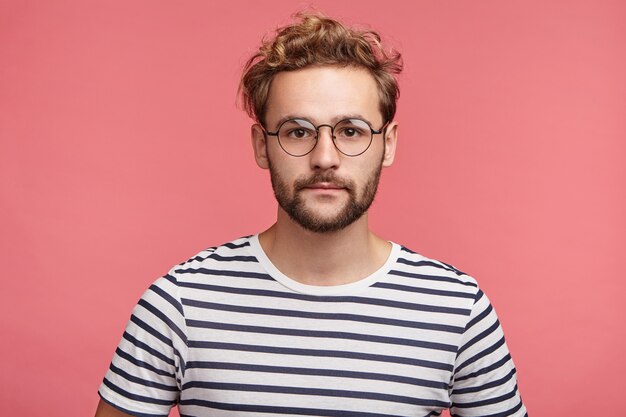 Indoor portrait of bearded young man with trendy hairstyle