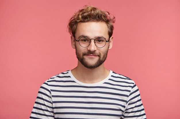 Indoor portrait of bearded young man with trendy hairstyle