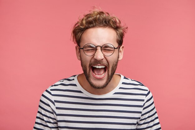 トレンディなヘアスタイルのひげを生やした若い男の屋内ポートレート
