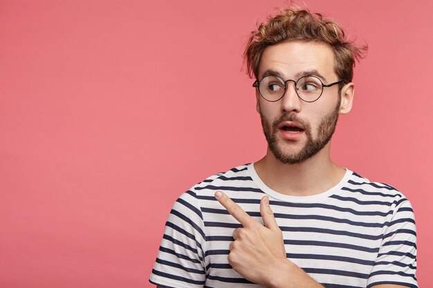 Indoor portrait of bearded young man with trendy hairstyle