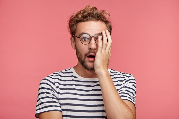 Indoor portrait of bearded young man with trendy hairstyle