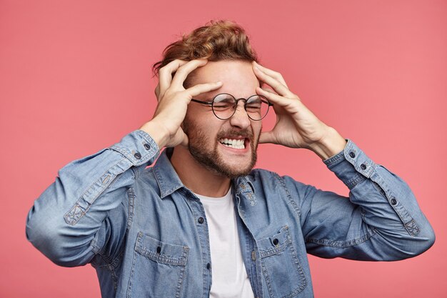 Indoor portrait of bearded young man with trendy hairstyle