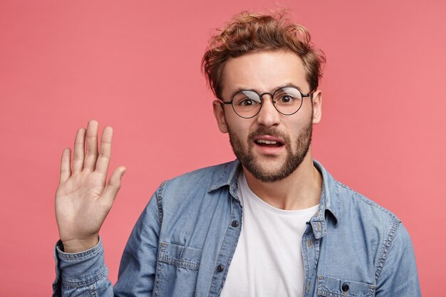 Indoor portrait of bearded young man with trendy hairstyle