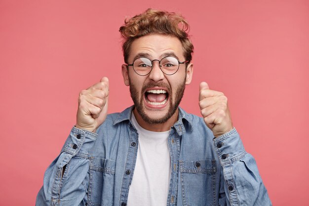 トレンディなヘアスタイルのひげを生やした若い男の屋内ポートレート