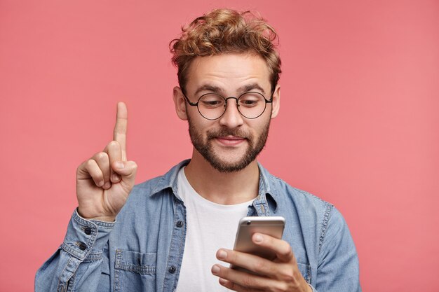 Indoor portrait of bearded young man with trendy hairstyle