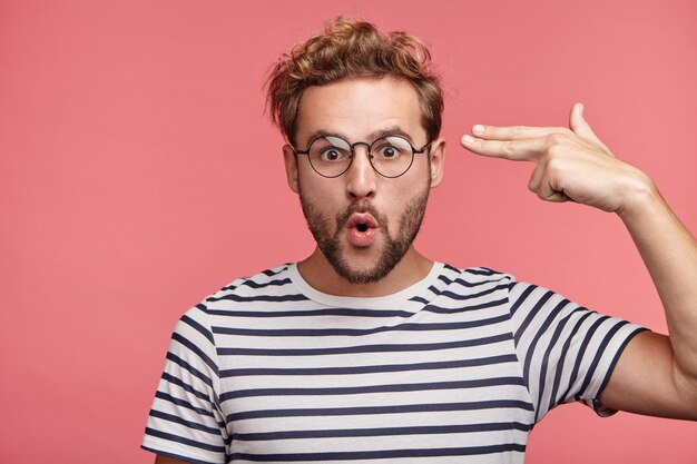 Indoor portrait of bearded young man with trendy hairstyle