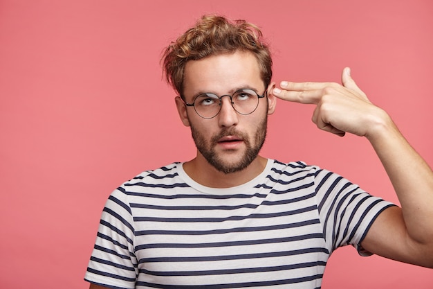 Indoor portrait of bearded young man with trendy hairstyle