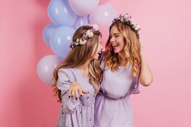 Free photo indoor portrait of long-haired woman in flower wreath spending time with friend at birthday party