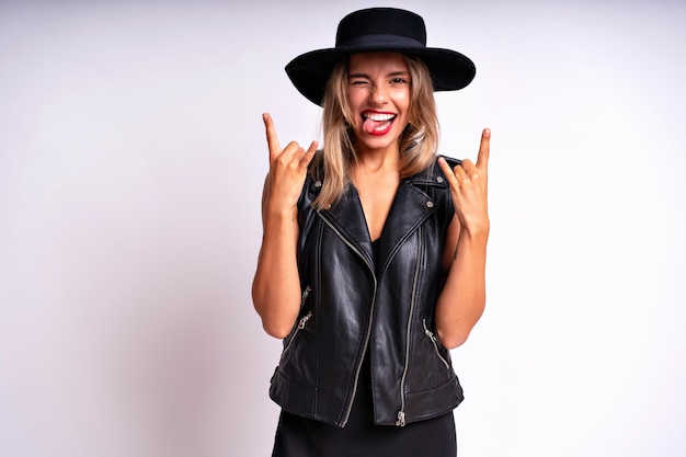 Indoor portrait of stylish woman wearing black dress and hat having fun, rock n roll style.