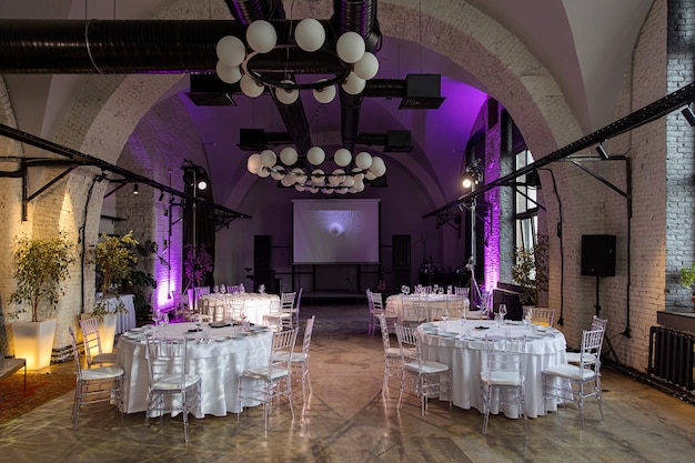 Внутренний зал со столиками для банкета или свадьбы Premium Фотографии