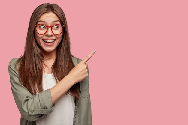 Indoor shot of attractive student posing against the pink wall