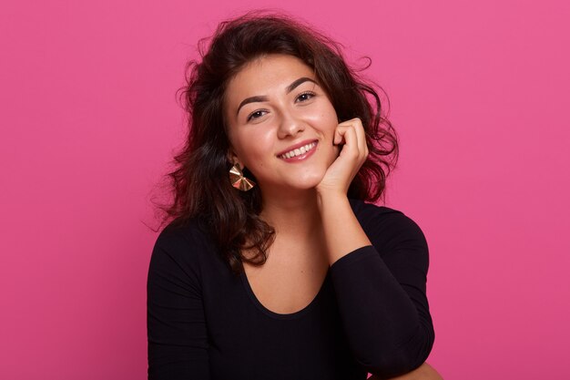 Indoor shot of beautiful girl smiling and looking directly at camera