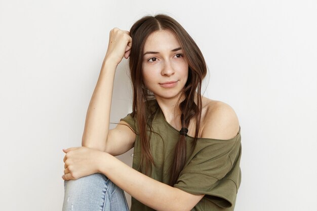 Indoor shot of beautiful young brunette female in stylish clothing