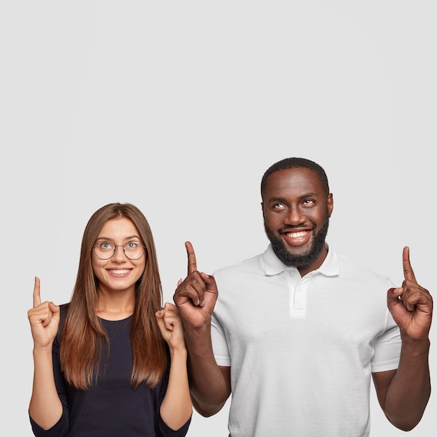 Free photo indoor shot of cheerful glad satisfied mixed race woman and man have broad smiles