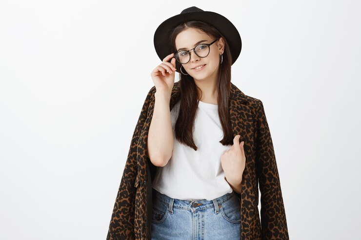 無料Photo 白い壁にポーズをとって自信を持ってスタイリッシュな若い女性の屋内ショット