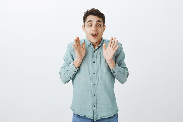 Indoor shot of excited happy male model in casual shirt