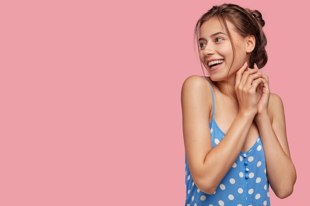 Indoor shot of happy smiling woman keeps hands together