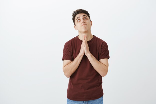 Indoor shot of hopeful handsome guy in casual outfit